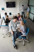 bonitas mujeres empresarias usando tableta en el edificio de oficinas durante la conferencia foto