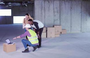 engineer showing house design plans to a young multiethnic couple photo