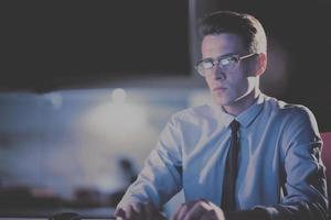 man working on computer in dark office photo