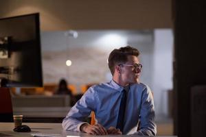 man working on computer in dark office photo