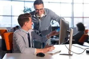 dos personas de negocios que trabajan con una computadora en la oficina foto