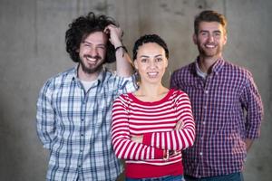 retrato de un equipo informal de negocios frente a un muro de hormigón foto