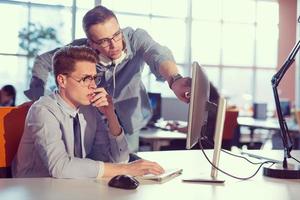 dos personas de negocios que trabajan con una computadora en la oficina foto