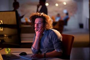 man working on computer in dark office photo