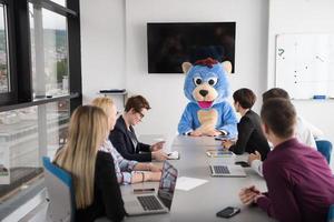 boss dresed as bear having fun with business people in trendy office photo