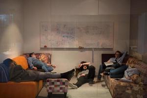 software developers sleeping on sofa in creative startup office photo