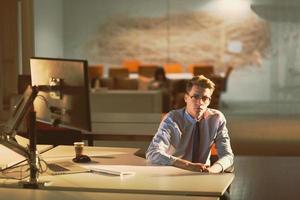 man working on computer in dark office photo