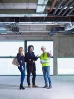 worker showing house design plans to a young couple photo