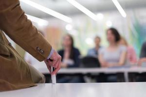 primer plano de la mano del maestro mientras enseña en el aula foto