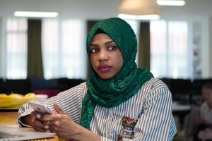 african muslim business woman using mobile phone photo