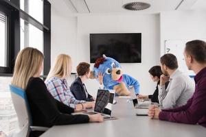 boss dresed as bear having fun with business people in trendy office photo