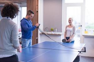 equipo de negocios de inicio jugando tenis de ping pong foto