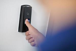 man pressing fingerprint scanner photo