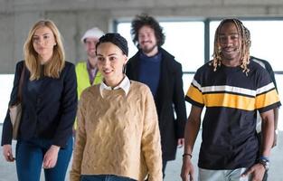 young multiethnic business people walking through unfinished startup office photo