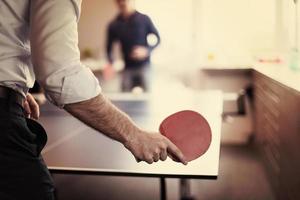 equipo de negocios de inicio jugando tenis de ping pong foto