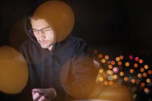 hacker using laptop computer while working in dark office photo