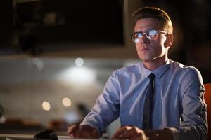 man working on computer in dark office photo