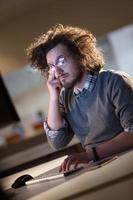 man working on computer in dark office photo