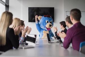 jefe vestido como oso divirtiéndose con gente de negocios en una oficina de moda foto