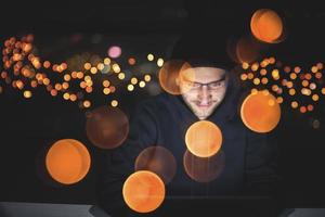 hacker using laptop computer while working in dark office photo