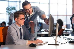 dos personas de negocios que trabajan con una computadora en la oficina foto