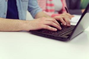 close up of student hands typing on laptop photo