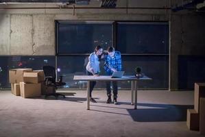 business people on construction site  in new startup office at night photo