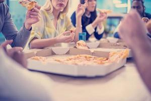 equipo de negocios multiétnico comiendo pizza foto