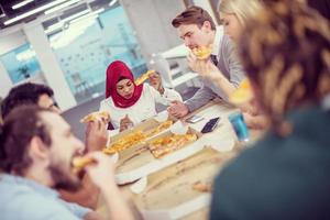 multiethnic business team eating pizza photo