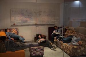 software developers sleeping on sofa in creative startup office photo