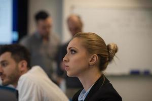 portrait of young business woman at office with team on meeting in background photo