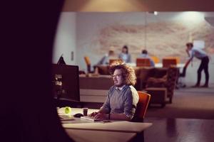 hombre trabajando en una computadora en una oficina oscura foto