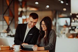 el hombre y la mujer modernos usan dispositivos modernos, computadoras portátiles, tabletas y teléfonos inteligentes y organizan nuevos proyectos para el trabajo. concepto de negocio . foto