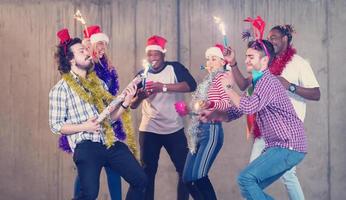 grupo multiétnico de empresarios casuales bailando con bengalas foto