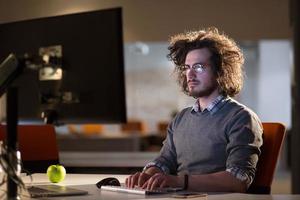 man working on computer in dark office photo