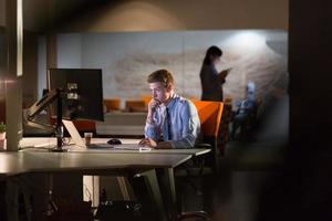 man working on computer in dark office photo
