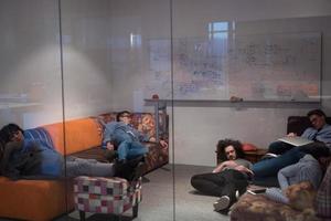 software developers sleeping on sofa in creative startup office photo