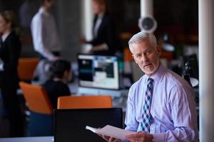 hombre de negocios senior con su equipo en la oficina foto