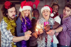 multiethnic group of casual business people lighting a sparkler photo