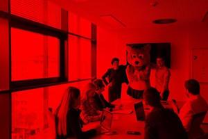 boss dresed as bear having fun with business people in trendy office photo