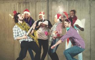 grupo multiétnico de empresarios casuales bailando con bengalas foto