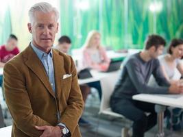 portrait of in teacher in classroom with students group in background photo