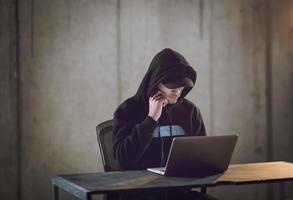 talented hacker using laptop computer while working in dark office photo