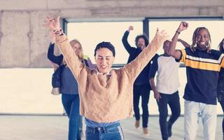 young multiethnic business people dancing in unfinished startup office photo