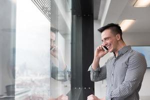 joven hombre de negocios hablando por teléfono inteligente en la oficina foto