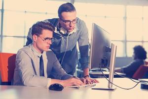 dos personas de negocios que trabajan con una computadora en la oficina foto