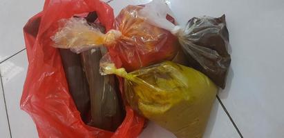 paquetes de alimentos eid envueltos en plástico para los niños de la pensión, que consisten en opor de pollo, salsa de chile frito con patata y verduras lodeh foto
