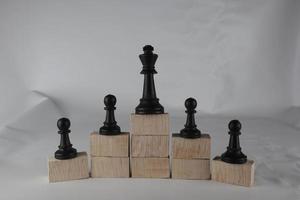 Chess pawn on the bottom and a chess queen on top, a concept to symbolize achievement, growth, and success. Business concept photo
