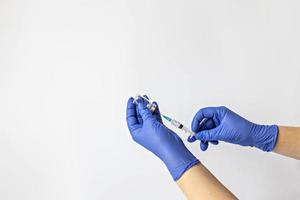 un trabajador médico con guantes médicos extrae una dosis de la vacuna contra el coronavirus en una jeringa. el concepto de vacunación, inmunización, prevención de personas contra el covid-19 foto