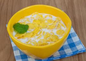 Cornflakes in a bowl on wooden background photo